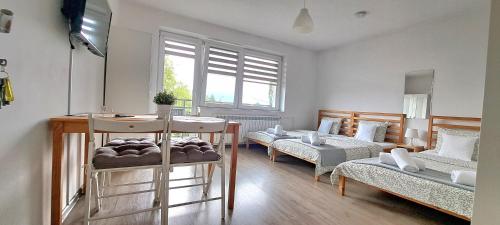 a living room with two beds and a table at Pokoje i Apartamenty na Szkolnej in Zator