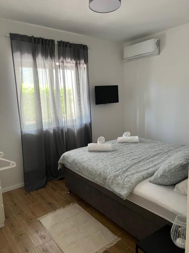 a bedroom with a bed with two towels on it at Gemini Apartments in Kaštela