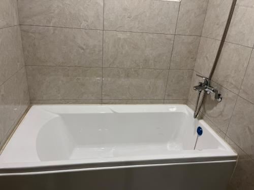 a white bath tub in a shower with a faucet at 飛鳥集行館 in Hu-hsia