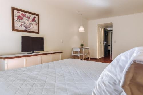 a bedroom with a bed and a flat screen tv at Soft Bariloche Hotel in San Carlos de Bariloche