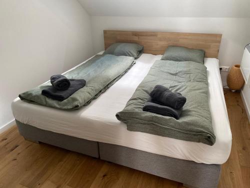 ein großes Bett mit zwei Decken und Handtüchern darauf in der Unterkunft Lendhafen in Klagenfurt am Wörthersee