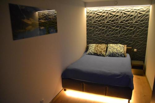 a small bed in a room with a wall at Luksusowy Apartament przy Galerii 8th floor in Kielce
