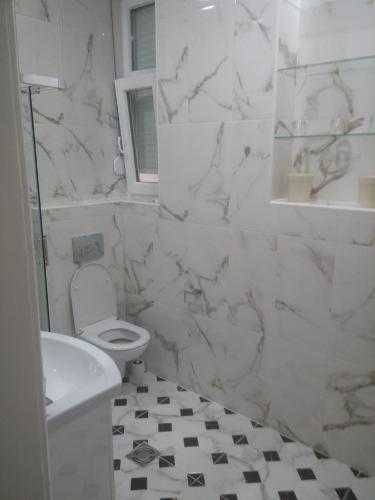 Baño blanco con aseo y lavamanos en Cricket 2 Hostel, en Belgrado