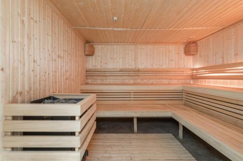 una sauna vacía con paredes y bancos de madera en Lux Wellness Resort Apartments by the River by Renters Prestige, en Dziwnów