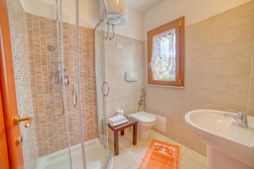 a bathroom with a shower and a sink and a toilet at Corsaro Azzurro Apartment in Stintino