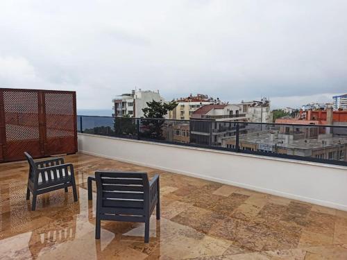 a balcony with two chairs and a view of a city at Royal Homes 504 in Antalya