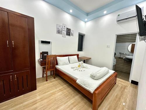 Khách sạn Anh Tuấn في Bạc Liêu: غرفة نوم بسرير ومكتب ومغسلة