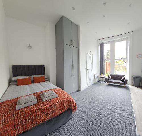 a bedroom with a large bed with an orange blanket at Edgerton Studios in Huddersfield