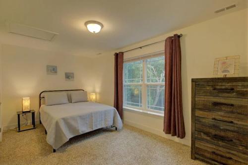 a bedroom with a bed and a dresser and a window at Lazy Bear-HotTub, Pet Friendly, Private home just 15 minutes to Asheville.. in Fairview
