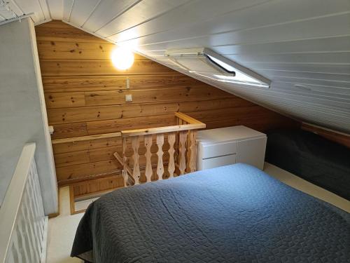 um pequeno quarto com uma cama num quarto com paredes de madeira em Ylläs Nilimaja em Ylläsjärvi