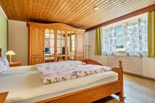 um quarto com uma cama e um tecto de madeira em Ferienwohnung Oberberg em Oberreute