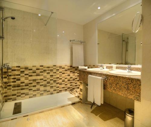 a bathroom with a tub and a sink and a mirror at Beatriz Toledo Auditorium & Spa in Toledo