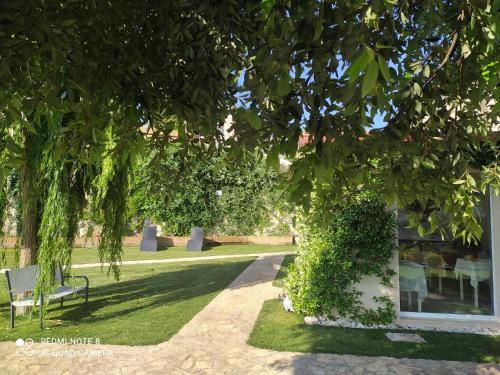 a park with a bench and trees and grass at B&B Volver in Peschici