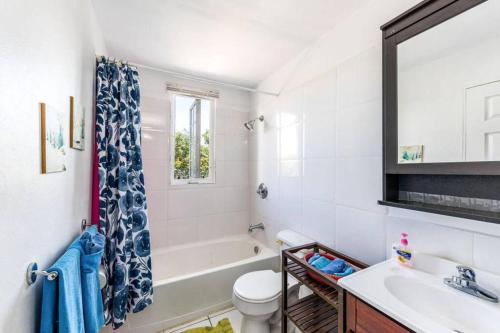 a bathroom with a tub and a toilet and a sink at 2 Bed 2bath Cottage Pickleball Court Pool in Providenciales
