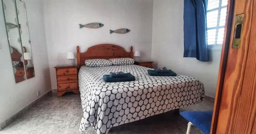 Un dormitorio con una cama con dos zapatos azules. en Casitas El Charcon en Arrieta