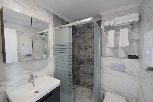 a white bathroom with a sink and a shower at Royal Homes 505 in Antalya