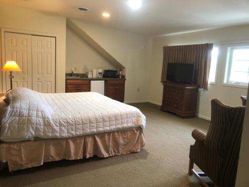 a bedroom with a bed and a television and a chair at Jiminy Peak Mountain Resort in Hancock