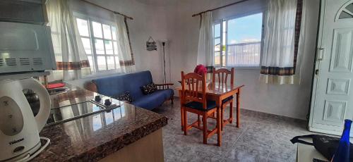 cocina y sala de estar con mesa y sofá en Casitas El Charcon, en Arrieta