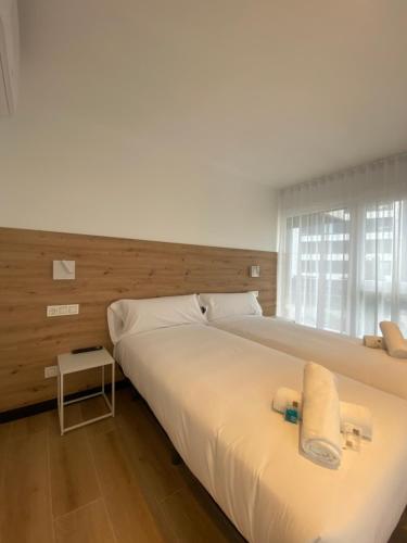 a bedroom with a large white bed and a window at DONOSTIA ROOMS in San Sebastián