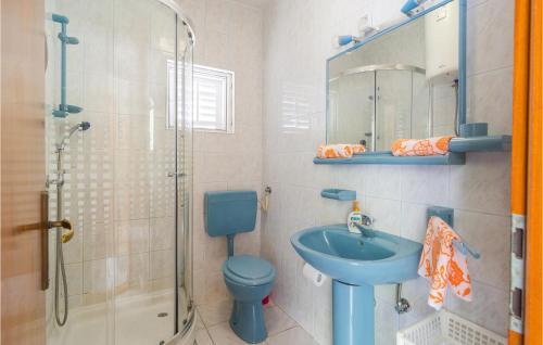 a bathroom with a blue toilet and a sink at Stunning Apartment In Pisak With House Sea View in Pisak