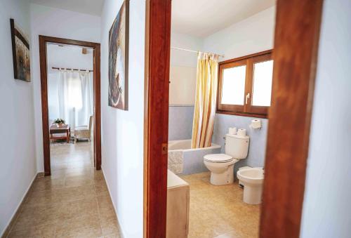a bathroom with a toilet and a bath tub at Can Lari Chalet in Vall-Llobrega