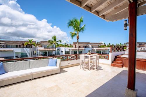 a patio with a couch and a table on a balcony at Xeliter Balcones del Atlantico - Las Terrenas in Las Terrenas