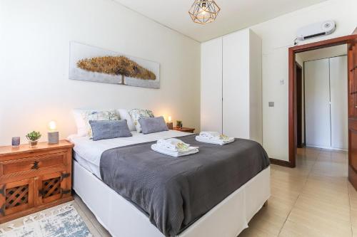 um quarto com uma cama grande e uma cómoda em madeira em Vita Portucale ! Sandset Park View em Costa da Caparica