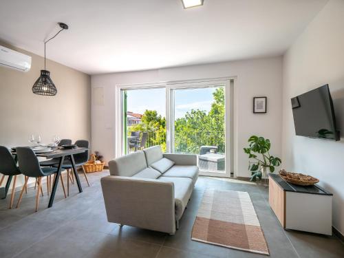 uma sala de estar com um sofá e uma mesa em Sunny side Apartments em Malinska