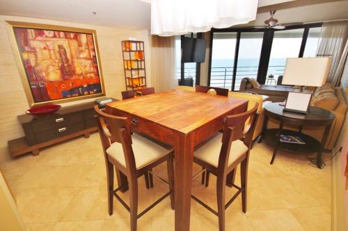 a living room with a wooden table and chairs at Ebb Tide 703 in New Smyrna Beach