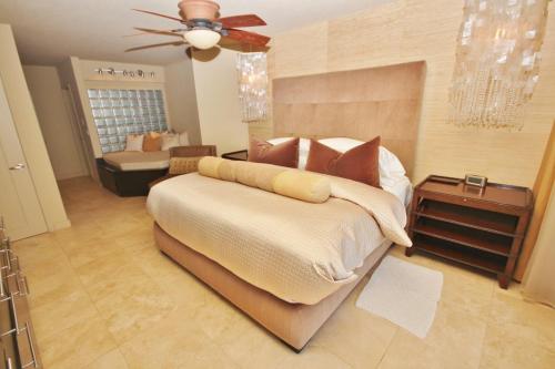 a bedroom with a large bed with a ceiling fan at Ebb Tide 703 in New Smyrna Beach