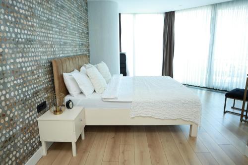 1 dormitorio con cama blanca y pared de ladrillo en Pullman Prime-I-BDROOM en Estambul