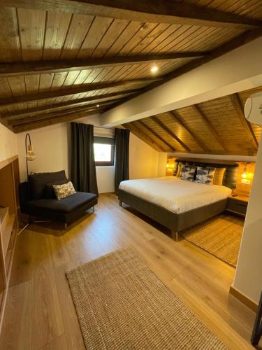 a bedroom with a bed and a couch in a room at Villa D’Aurora Country Suites in Ponte de Lima