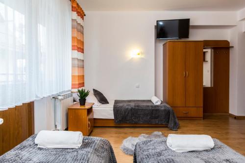 a room with two beds and a flat screen tv at Willa Danuśka in Zakopane