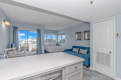 een keuken en een woonkamer met een blauwe bank bij The Palace 1505 in Myrtle Beach