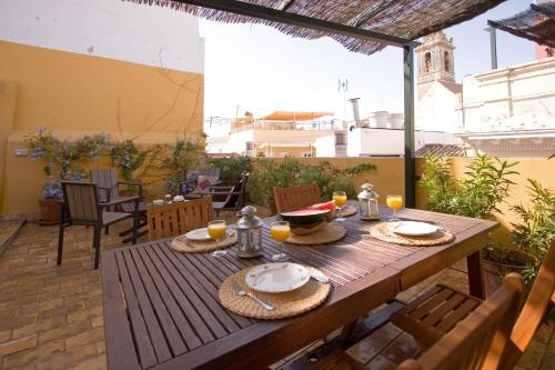 a wooden table with plates of food on a patio at Bamberg Duplex Terrace in Seville