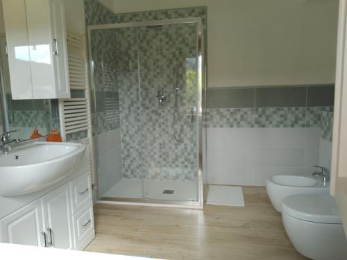 een badkamer met een douche, 2 wastafels en een toilet bij Le sette fontane in Barga