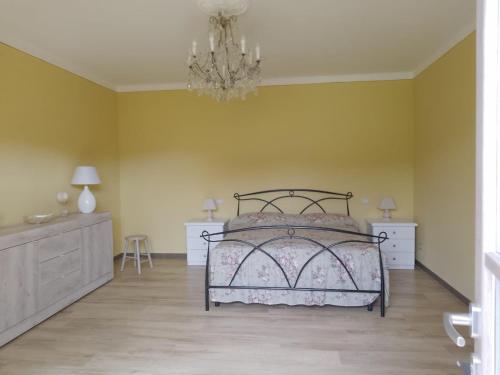 sypialnia z łóżkiem i żyrandolem w obiekcie Le sette fontane w mieście Barga