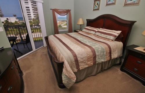 a bedroom with a bed and a balcony at Oceanwalk 13-404 in New Smyrna Beach