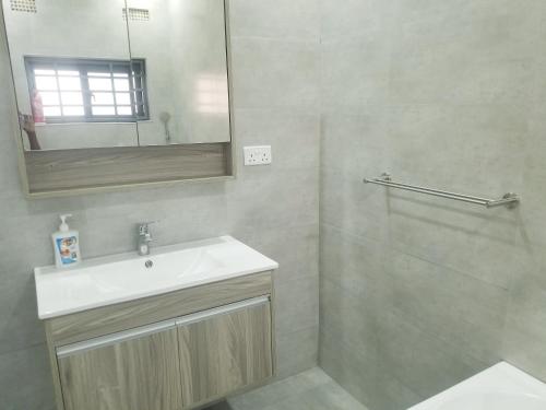 a bathroom with a sink and a mirror at JC Apartments in Ndola