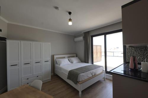 a bedroom with a bed and a table and a window at Royal Homes 506 in Antalya