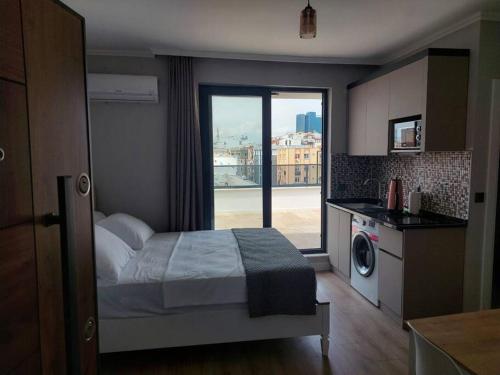 sypialnia z łóżkiem oraz kuchnia z oknem w obiekcie Royal Homes 506 w mieście Antalya