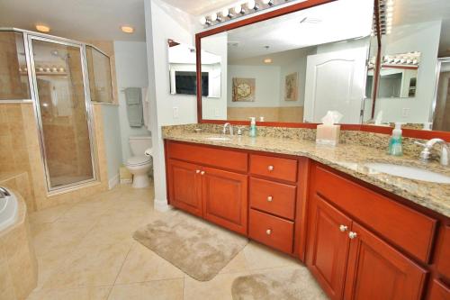 y baño con 2 lavabos y ducha. en Oceanwalk 13-406, en New Smyrna Beach