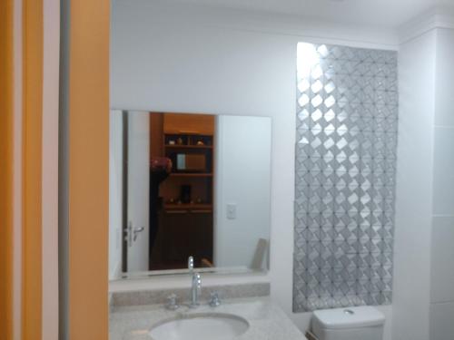 a bathroom with a sink and a mirror and a toilet at Stúdio lindo no Tatuapé in São Paulo