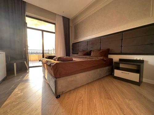 a bedroom with a large bed and a large window at Sun City Hotel & Spa Naftalan in Naftalan