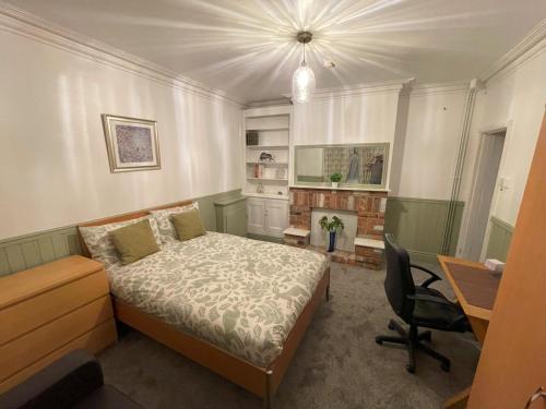 a bedroom with a bed and a desk and a chair at Self-Contained Ground Floor Flat in Nottingham