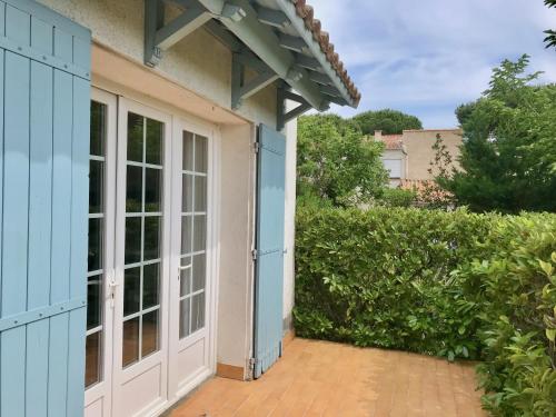 une porte ouverte menant à une maison dotée d'une terrasse. dans l'établissement Lady Blue, villa à 15 mn plage à pied, parking, wifi, jardin, à La Grande Motte