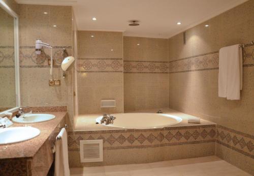 a bathroom with two sinks and a bath tub at Beatriz Toledo Auditorium & Spa in Toledo