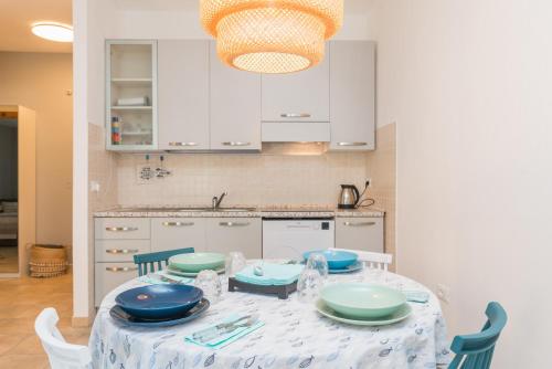 サンタ・テレーザ・ガッルーラにあるLoriana seaside homeのキッチン(テーブル、青と白の椅子付)