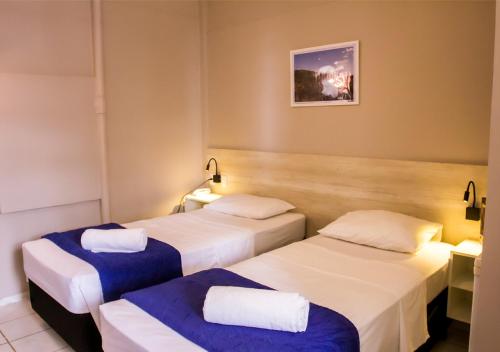 Europa Hotel Brasília في تاغاتينغا: غرفه فندقيه سريرين بشرشف ازرق