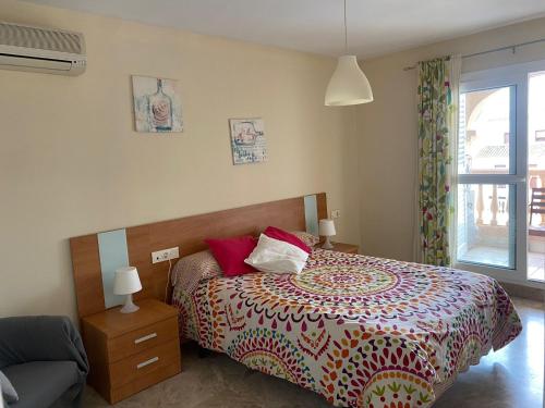1 dormitorio con 1 cama con colcha colorida en Apartamento Portofino Golf & Puerto Almerimar, en Almerimar